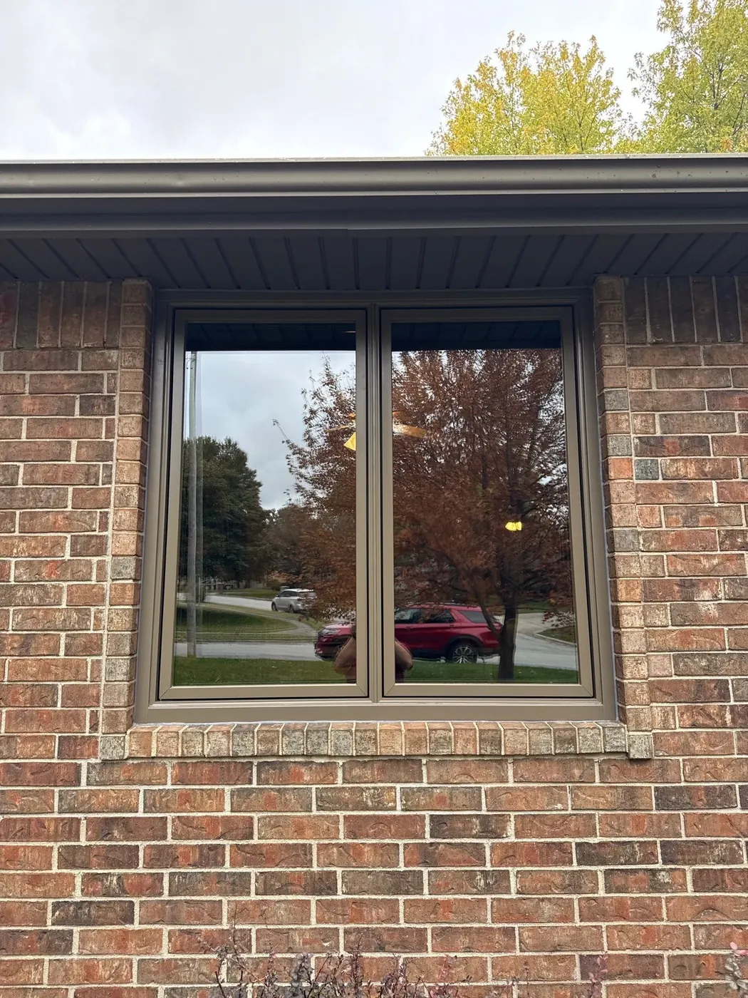 After: the replacement window finishes the brick opening with a cleaner, brighter look.